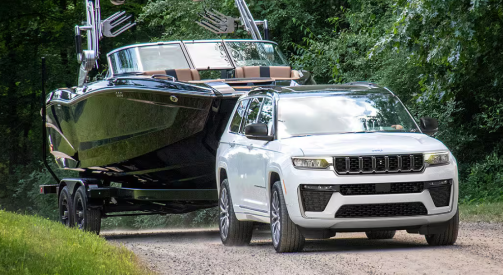 White 2026 Jeep Grand Cherokee towing a boat