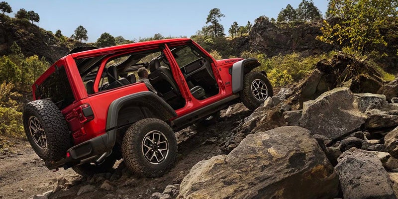 Red 2026 Jeep Wrangler driving off-road