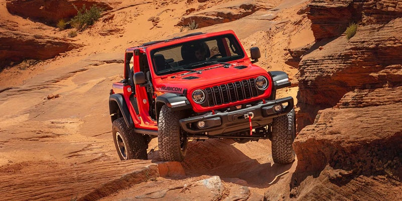 Red 2026 Jeep Wrangler driving off-road
