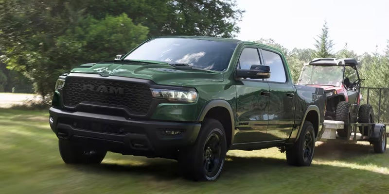 Green 2026 Ram 1500 towing a trailer