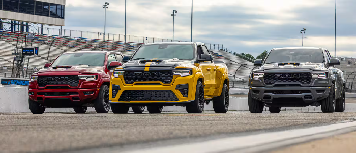Three 2027 Ram 1500 Rumble Bee trucks parked on raceway